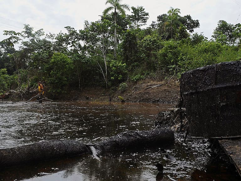 Un trabajador de la empresa estatal Petroecuador intenta limpiar el crudo que se derramara en un afluente en Ecuador.