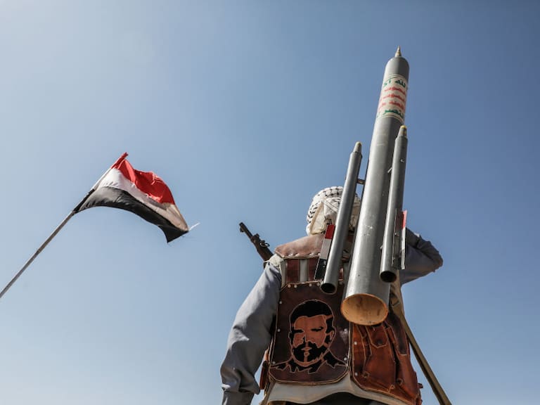 Un miembro del grupo rebelde llamados hutíes camina por Saná en Yemen portando un proyectil, en medio del conflicto con Estados Unidos.