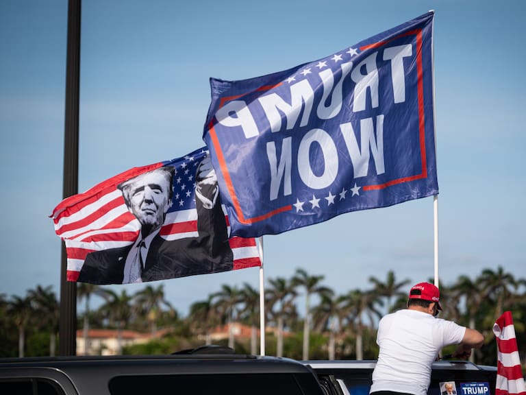 Un seguidor de Donald Trump con banderas del candidato presidencial en la localidad de Palm Beach en Florida.