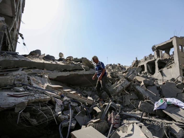 Hombre camina entre los escombros que dejan los ataques de Israel en Gaza