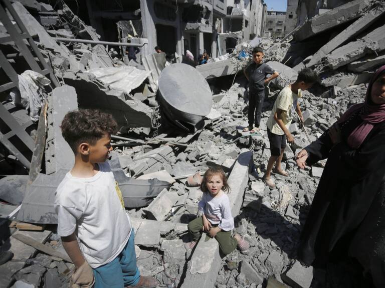 Familia palestina observa la destrucción de viviendas y edificios en la Franja de Gaza que dejan los ataques de Israel.