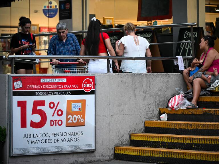 Una mujer con un bebé piden dinero a un costado de un centro comercial en la ciudad de Buenos Aires en Argentina.