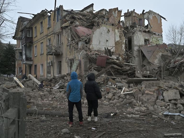 Personas observan la destrucción de un edificio que dejan los ataques aéreos de Rusia en la localidad de Selídove, en la región de Donetsk en Ucrania.