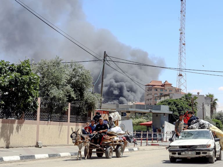 El humo se levanta luego de un ataque aéreo contra Rafah, mientras una familia palestina intenta huir de esa zona en la Franja de Gaza.