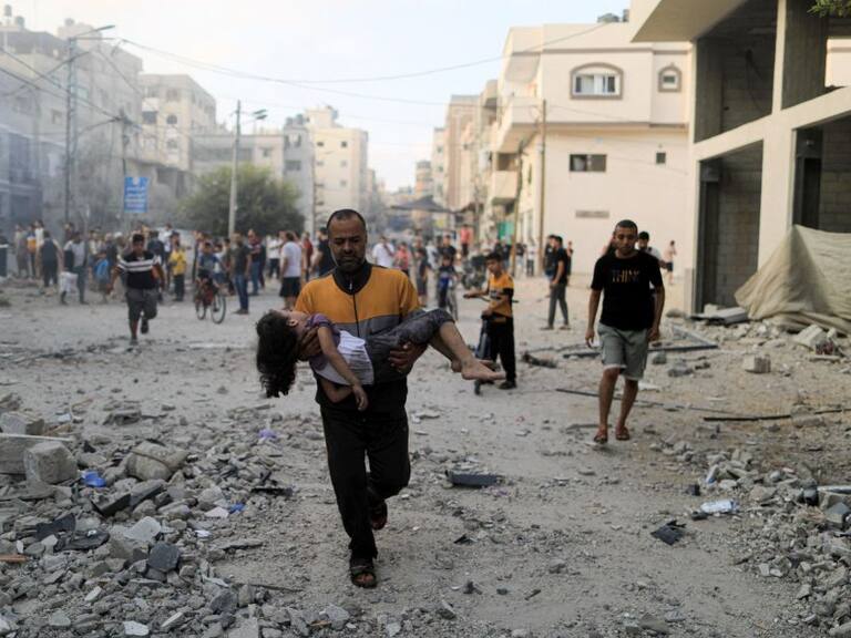 Un palestino lleva una niña herida tras un bombardeo de Israel sobre Gaza