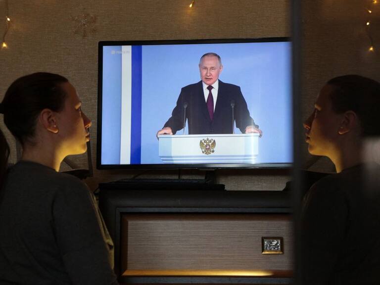Mujer mira un mensaje en televisión del presidente de Rusia Vladimir Putin
